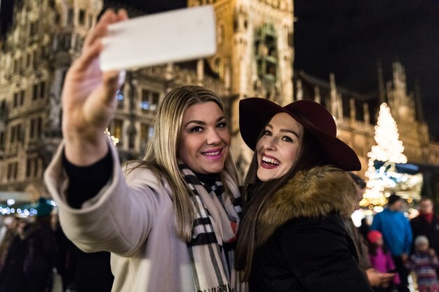 Kobiety biorące selfie na jarmarku bożonarodzeniowym w Monachium