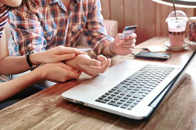 Zdjęcie kobiety ciepłe trzymają rękę człowieka na zakupy online kartą kredytową i laptopem, pożyczki rodzinne