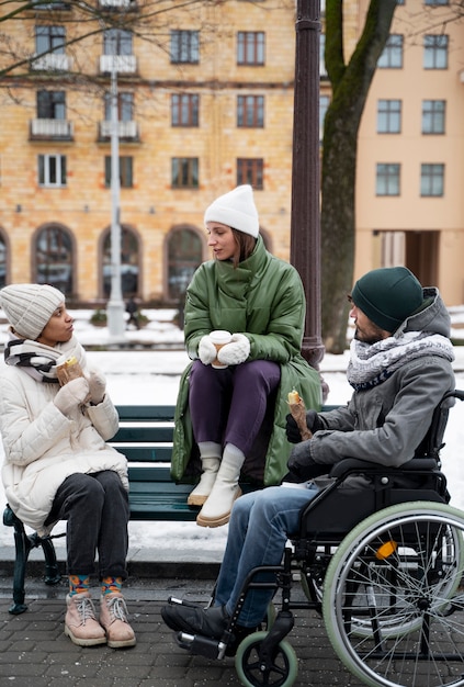 Kobiety cieszące się czasem ze swoim przyjacielem na wózku inwalidzkim