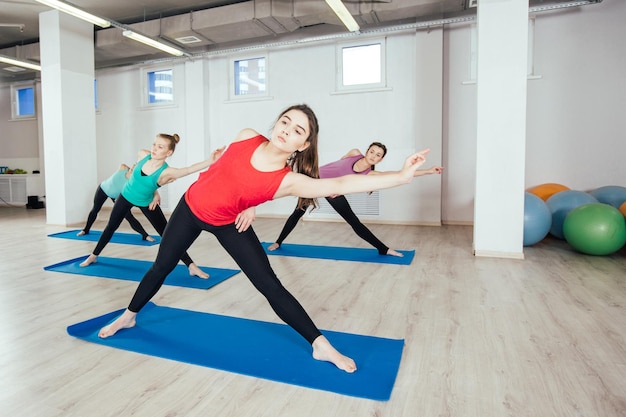 Kobiety ćwiczą ćwiczenia jogi w studio itness sport ludzie i koncepcja zdrowego stylu życia