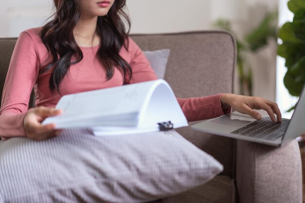 Kobiety czytające dokument biznesowy finansów i wpisując dane na laptopie podczas pracy w domu