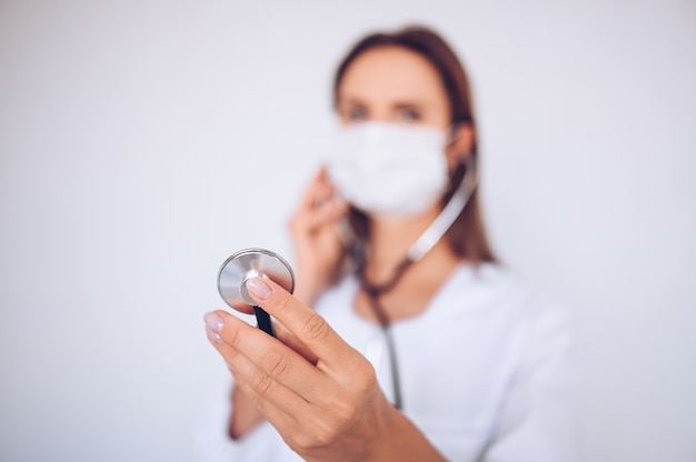 Kobiety doktorska pielęgniarka jest ubranym maskę ochronną i stetoskop dla sprawdzać oddychanie, zapobieganie wirusowi korona, higiena, aby przestać rozprzestrzeniać koronawirusa. Unikaj zanieczyszczenia koncepcji wirusa Covid-19 wirusa korony