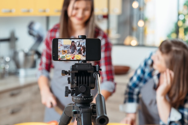 Kobiety fotografowania procesu gotowania na aparacie w telefonie