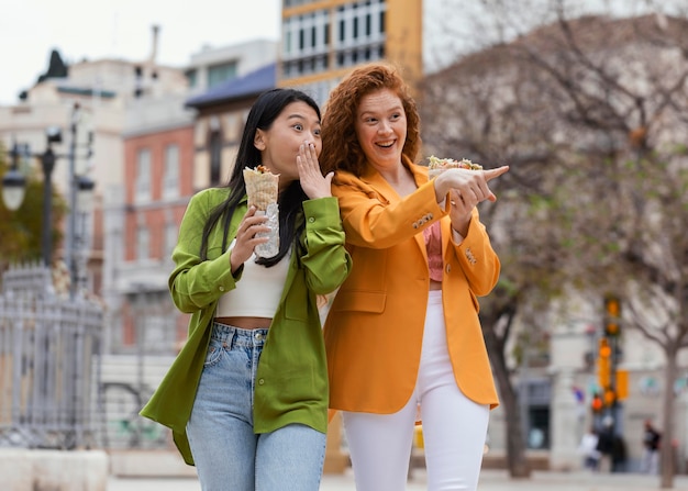 Zdjęcie kobiety jedzące uliczne jedzenie na świeżym powietrzu