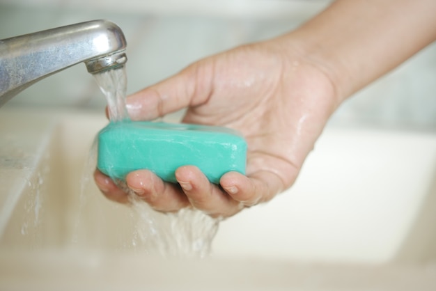 kobiety myjące ręce ciepłą wodą z mydłem