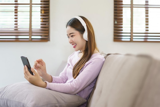 Kobiety noszące słuchawki do słuchania muzyki i rozmowy na smartfonie w stylu życia w domu