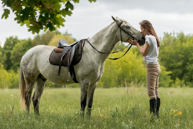 Zdjęcie kobiety odprowadzenie z koniem na wsi