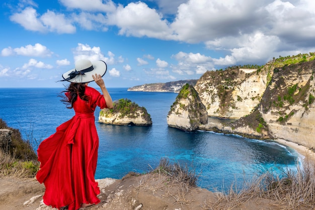 Zdjęcie kobiety pozycja na diament plaży w nusa penida wyspie, bali w indonezja.