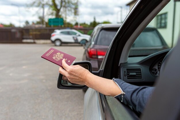 Zdjęcie kobiety przekazują paszporty do kontroli celnej przez okno samochodu