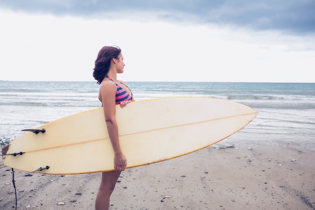 Kobiety przewożenia surfboard na plaży