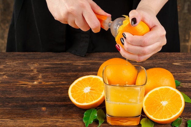 Kobiety ręka ściska soku pomarańczowego zakończenie up