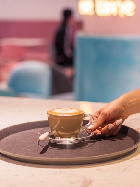 Kobiety ręka trzyma filiżankę kawy w restauraci