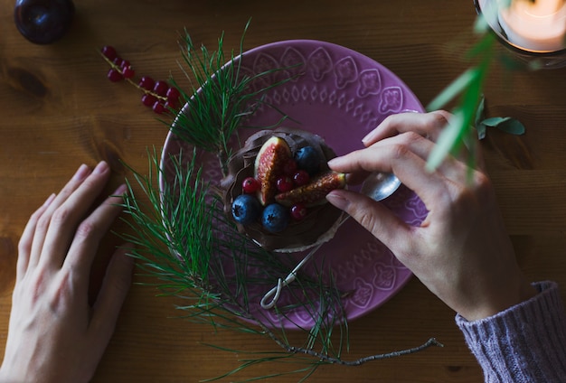 Zdjęcie kobiety ręki mienia babeczka z jagodami na boże narodzenie stole