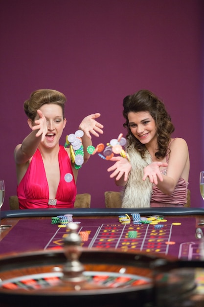Kobiety rzucają żetony na stole do ruletki