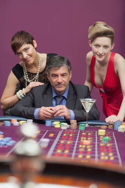 Kobiety stojące z człowiekiem przy stole do ruletki