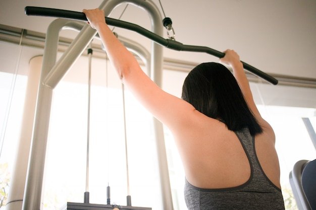 Kobiety treningu ławki prasy kabla maszyna w sprawności fizycznej gym.
