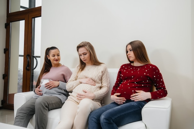 Kobiety W Ciąży Siedzą Na Kanapie I Bawią Się Ze Sobą Na Czacie. Ciąża I Dbanie O Przyszłość Dziecka