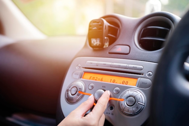 Kobiety włączają przycisk radia samochodowego do słuchania muzyki
