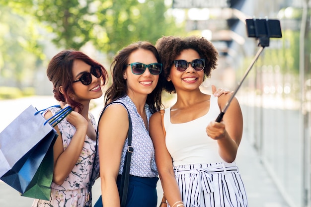 Zdjęcie kobiety z torbami na zakupy robiące selfie na świeżym powietrzu