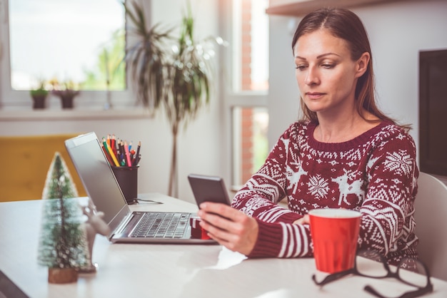 Kobiety za pomocą smartfona w domowym biurze