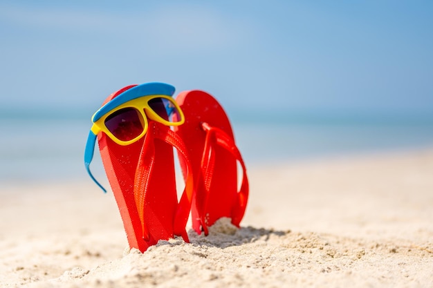 Kobiety żółte Okulary Przeciwsłoneczne I Czerwone Klapki Na Piasku Podróż Morzem Wakacje Na Plażytropikalna Piaszczysta Plaża Letnie Podróże Wakacje I Koncepcje Wakacji Letnich