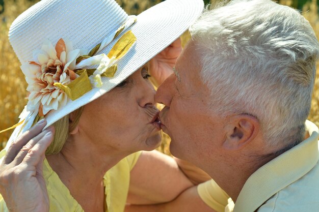 Zdjęcie kochająca dojrzała para całuje się w letnim parku