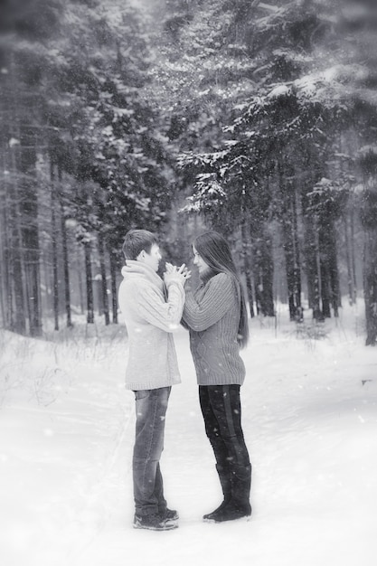 Kochająca para na zimowym spacerze. Mężczyzna i kobieta na randce w parku w zimie. Przyjaciele w zimowym parku