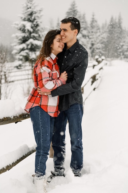 Kochająca para w koszuli na zimowy spacer. Mężczyzna i kobieta zabawy w mroźnym lesie. Romantyczna randka w okresie zimowym.Świąteczny nastrój młodej rodziny.Zimowa historia miłosna