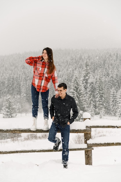 Kochająca para w koszuli na zimowy spacer. Mężczyzna i kobieta zabawy w mroźnym lesie. Romantyczna randka w okresie zimowym.Świąteczny nastrój młodej rodziny.Zimowa historia miłosna