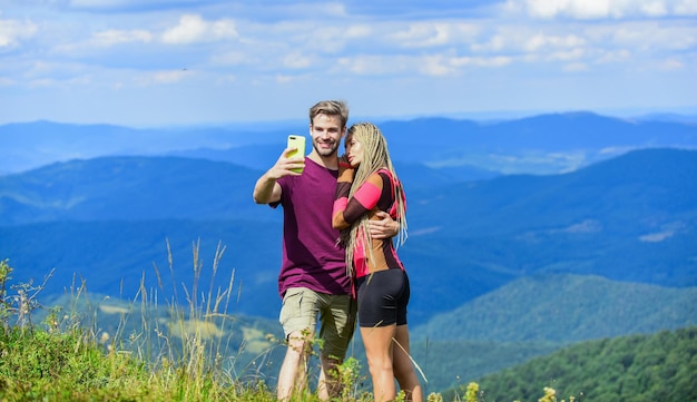 Kochający ludzie szczęśliwi, że są razem mężczyzna i kobieta w górach romantyczne selfie Walentynki poczucie wolności Podróżująca para zrobić selfie zakochana para Związek rodzinny