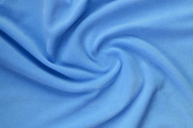 Kocyk z futrzanej, niebieskiej tkaniny z polaru. Tło jasnoniebieskiego miękkiego pluszowego materiału polarowego