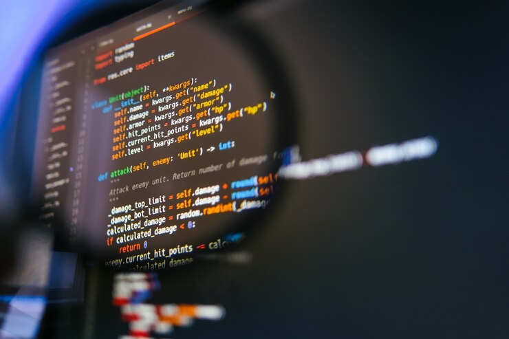 Zdjęcie kod programu na ekranie komputera w lupie. zbliżenie