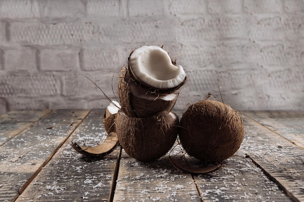 Zdjęcie kokos i mleko połamane kokosowe kokosowe na tle drewnianych desek