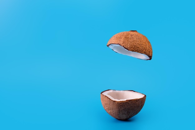 Kokos podzielony na pół i latający na niebieskim tle Kokos lewitujący obiekt koncepcyjny podium