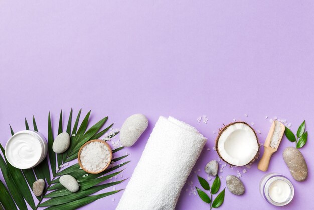Kokos ze słoikami oleju kokosowego i kremem kosmetycznym na kolorowym tle Widok z góry Wolne miejsce na tekst Naturalne kosmetyki kokosowe spa i koncepcja leczenia organicznego Skład Coconut Spa