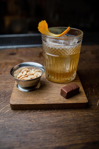 Koktajl alkoholowy z orzeszkami ziemnymi i cukierkami na drewnianym stole