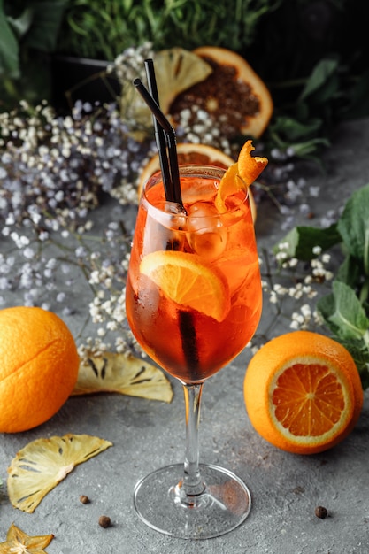 Koktajl Aperol Spritz na szarym betonowym stole. szklanka aperolowego spritzu z pomarańczowymi plasterkami. Letni koktajl w szklance