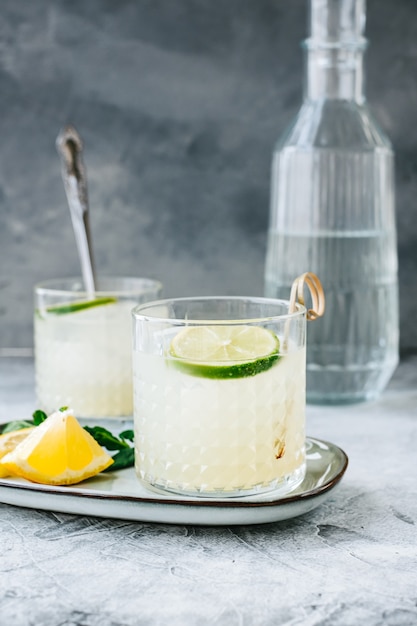 Koktajl cytrusowy z sokiem z cytryny i limonką w szklance na stole