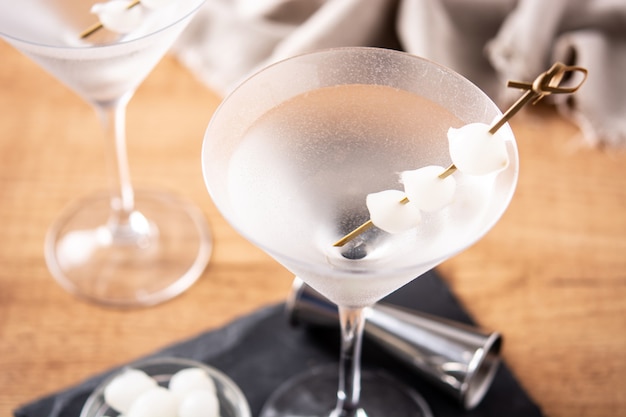 Zdjęcie koktajl martini gibson z cebulą na drewnianym stole