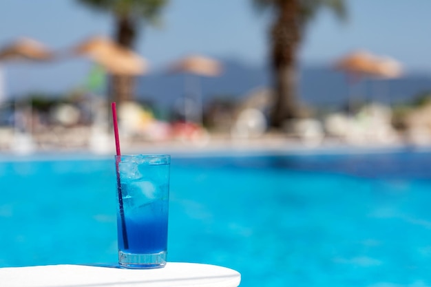 Koktajl z Błękitnej Laguny z lodem w pobliżu basenu w słoneczny dzień Letnie napoje bezalkoholowe