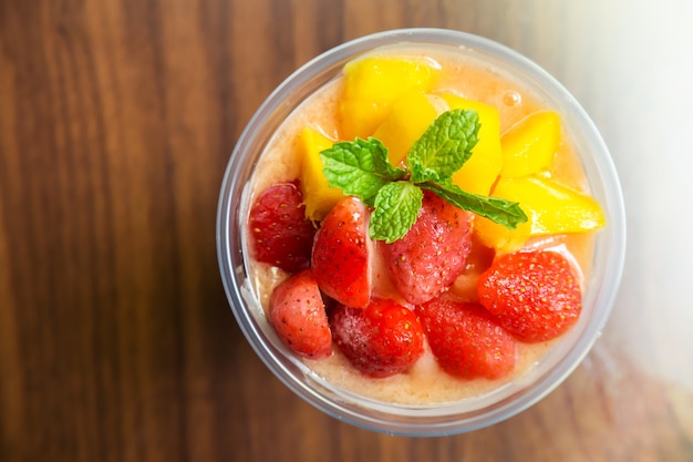 Koktajl z mango i truskawek w plastikowym kubku. Napój zdrowy napój.