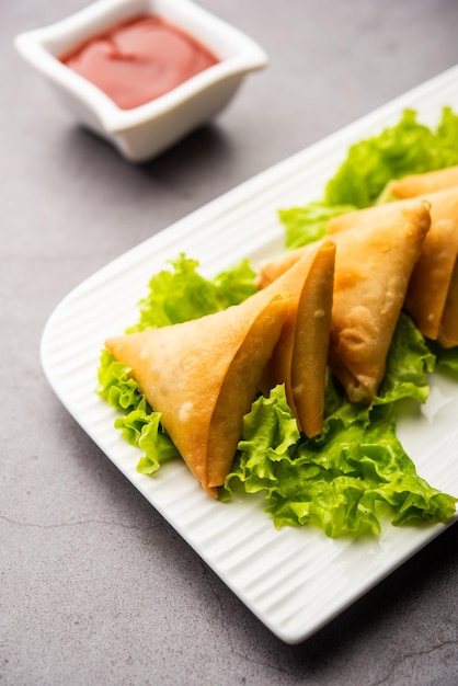 Koktajlowe mini trójkątne samosa z patti lub strips, popularna domowa przekąska z Indii