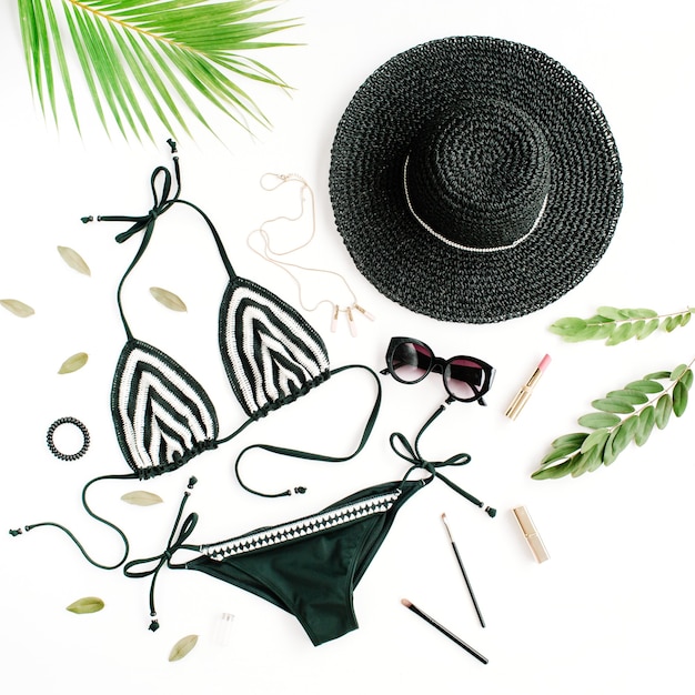 Zdjęcie kolaż damski letni strój kąpielowy bikini na białym tle z kapeluszem, zielonymi gałązkami, naszyjnikiem i okularami przeciwsłonecznymi