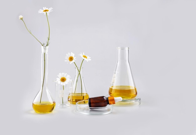 Kolby laboratoryjne z odczynnikami butelka na olejek eteryczny i kwiaty rumianku