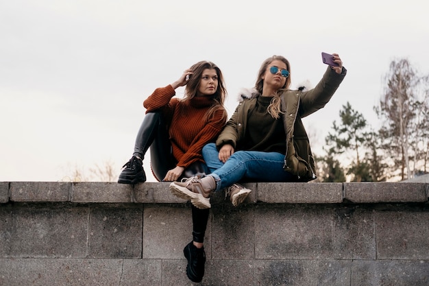 Zdjęcie koleżanki, biorąc selfie razem na zewnątrz