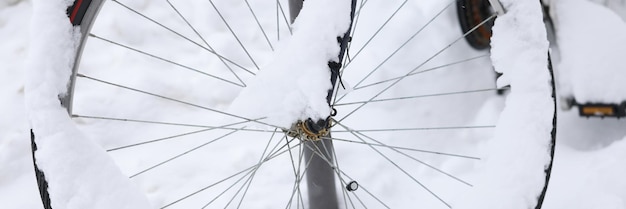 Koło rowerowe pokryte jest śniegiem na koncepcji przechowywania rowerów ulicznych