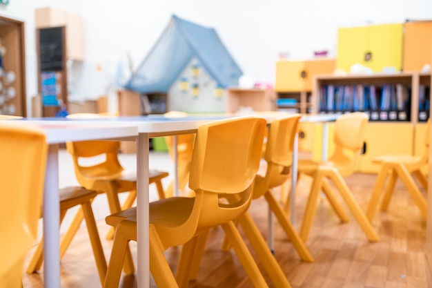 Zdjęcie kolorowa klasa przedszkolna bez dziecięcej edukacji szkolnej biurko zabawka i dekoracja na ścianie w tle dzieciństwo