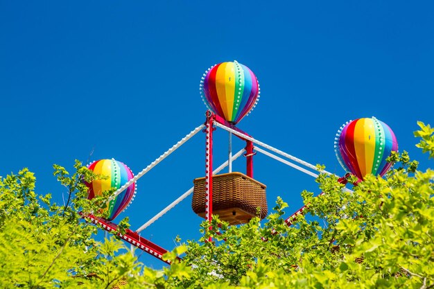 Kolorowe balony na małym koszu diabelskim młynie