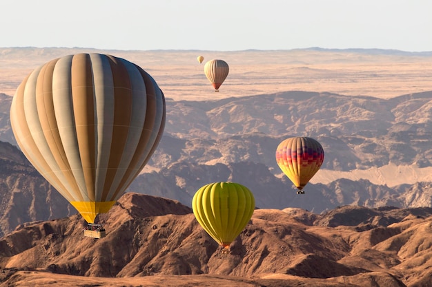 Kolorowe balony na ogrzane powietrze latające nad księżycową doliną górską w Afryce