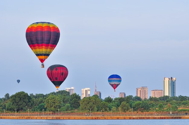 Kolorowe balony na ogrzane powietrze w locie nad błękitnym niebem